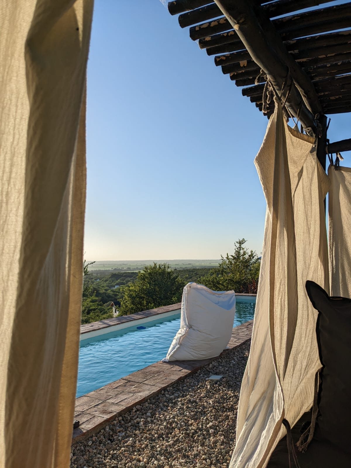 Pool and valley view through the pergola at golden hour
