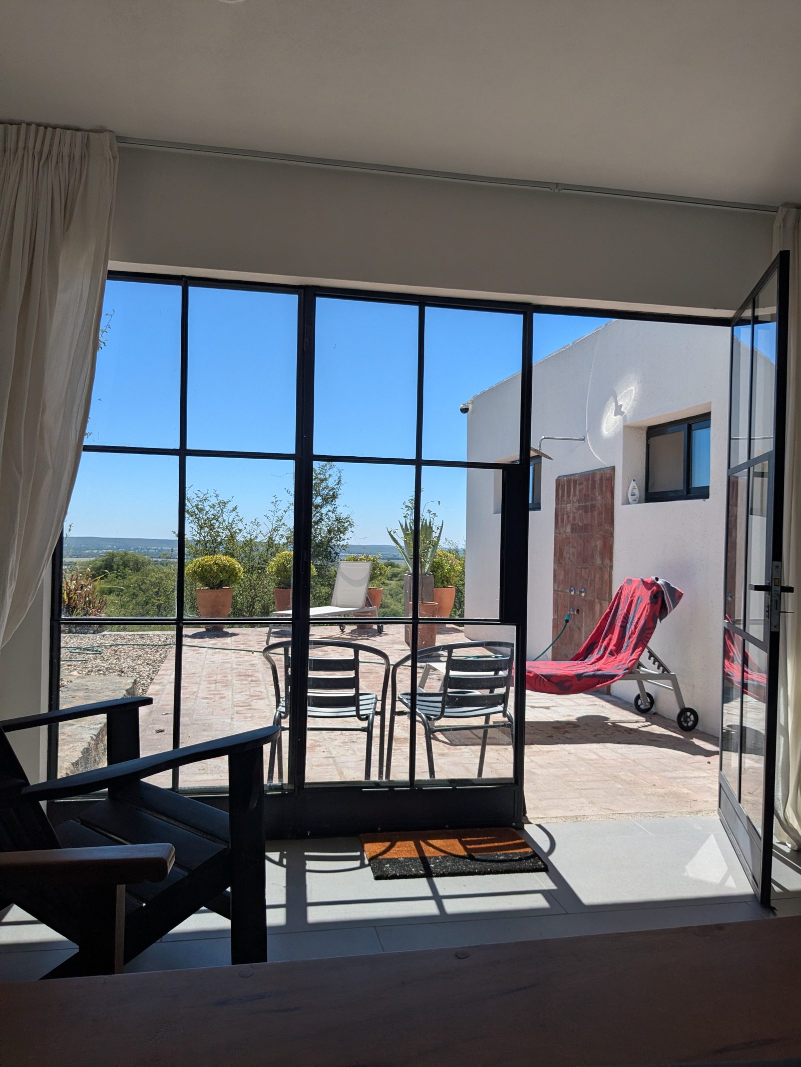 View through steel-frame windows to the terrace and valley