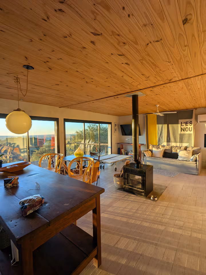 Open-plan living room with wood stove at golden hour